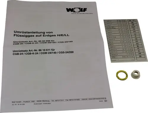 Wolf Umrüstsatz für Flüssiggas auf Erdgas, bestehend aus Anleitung, einem Ring und einem weiteren Bauteil, auf einem weißen Hintergrund.